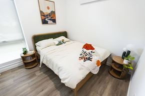 Portland apartment for rent - a bedroom with a bed with a white comforter and pillows at Brookland Apartments, Oregon 97202