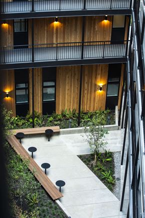 Portland apartment for rent - a courtyard with benches and plants in front of a building at Brookland Apartments, Portland, Oregon