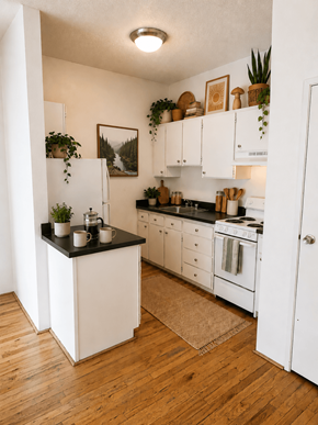 Portland apartment for rent - A kitchen with white cabinets and a black countertop.