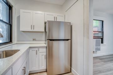 Portland apartment for rent - A kitchen with a stainless steel refrigerator and white cabinets.