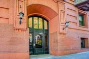 Portland apartment for rent - A red brick building with a black door and two lamps on either side at Clay & Tiffany, Portland, 97201