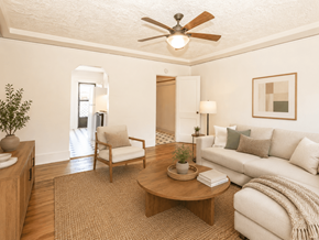 Portland triplex for rent - A living room with a white couch, a wooden coffee table, and a ceiling fan.