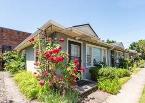 Portland triplex for rent - A house with a flower bed in front of it.