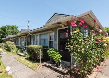 Portland triplex for rent - A house with a grey roof and a flower box on the front.