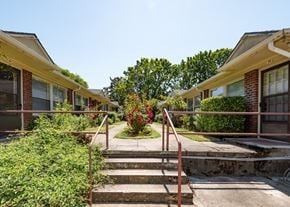Portland triplex for rent - A row of houses with a red metal railing in front of them.