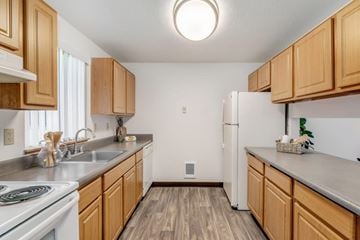 Vancouver townhouse for rent - A kitchen with wooden cabinets and a white refrigerator.