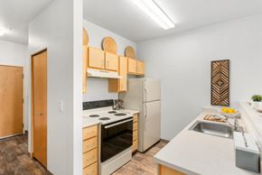 Portland apartment for rent - A kitchen with a white counter top and a white refrigerator.at Fifth Avenue Place Apartments, Oregon