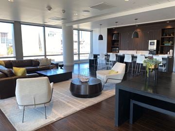 Portland apartment for rent - A modern living room with a black coffee table and white chairs.