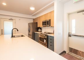 Portland apartment for rent - A modern kitchen with wooden cabinets and stainless steel appliances at Society 62 Apartments, Oregon