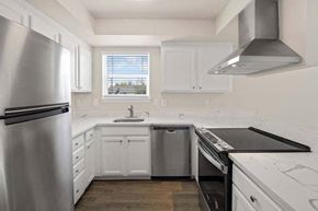 Tacoma townhouse for rent - a kitchen with a stove top oven next to a refrigerator