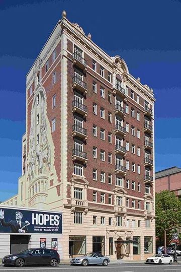 Portland apartment for rent - A tall building with a statue on the side and a banner that says "Hopes" on the front.