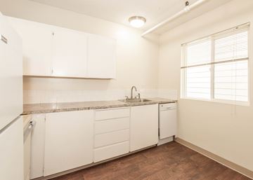 Portland apartment for rent - A kitchen with white cabinets and a granite countertop.
