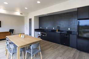 Portland apartment for rent - a kitchen and dining room with black appliances and a wooden table at Shift, Portland