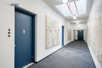Brooklyn apartment for rent - A hallway with a blue door and a white wall with a drawing on it.