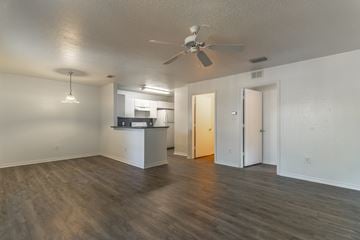 Fort Pierce apartment for rent - A room with a ceiling fan and a kitchenette in the background.