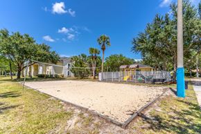 Fort Pierce apartment for rent - A sandy playground area with a blue pole and a fence in the background.