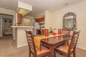 Columbia apartment for rent - a dining area with a table and chairs and a kitchen in the background at Arbors at Windsor Lake, Columbia, 29223
