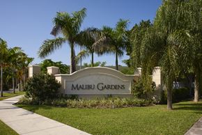 Homestead apartment for rent - a sign gardens in front of palm trees