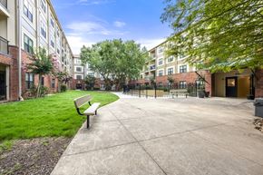 Atlanta apartment for rent - A bench is situated on a concrete area in front of a building.