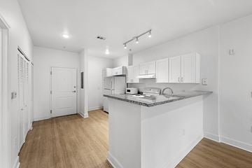 Atlanta apartment for rent - A kitchen with white cabinets and a wooden floor.