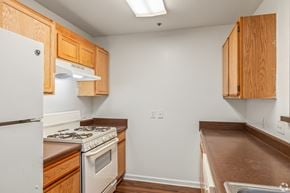 Pensacola apartment for rent - A kitchen with wooden cabinets and a white refrigerator.