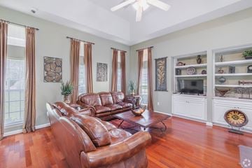 North Charleston apartment for rent - A living room with a brown leather couch and a fan on the ceiling.