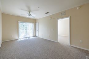 Port Richey apartment for rent - A spacious room with a ceiling fan and carpeted floor.