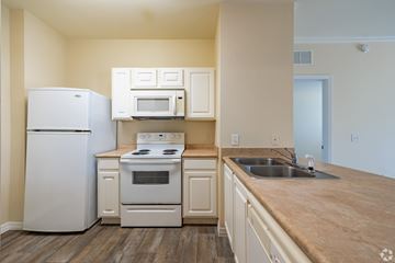 Port Richey apartment for rent - A kitchen with a white refrigerator, stove, and microwave.