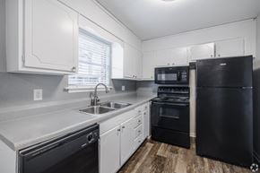 Goose Creek apartment for rent - A kitchen with black appliances and white cabinets.at Brandywine Townhomes, Goose Creek, SC
