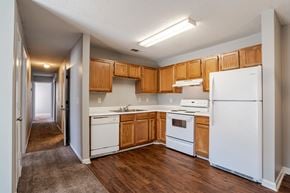 Travelers Rest apartment for rent - A kitchen with white appliances and wooden cabinets.at Brookside Pointe Apartments, Travelers Rest