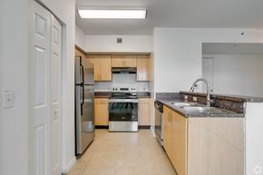 Miami apartment for rent - A kitchen with a refrigerator, oven, and sink.