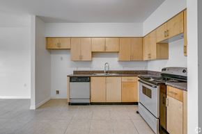 Miami apartment for rent - A kitchen with wooden cabinets and a stainless steel dishwasher.