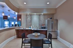 Greenville apartment for rent - A kitchen with a table and chairs in the foreground and a refrigerator in the background at The Bristol Apartments, Greenville, 29601