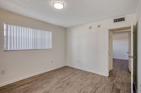 Miami apartment for rent - a bedroom with hardwood floors and white walls