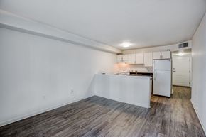 Miami apartment for rent - a kitchen and living room with white walls and wood flooring