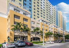 Miami apartment for rent - a large building with a parking lot in front of it