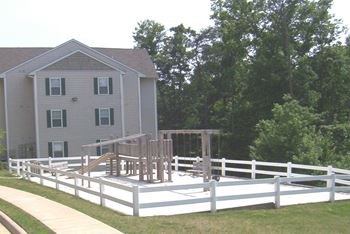 A white fence surrounds a playground