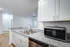 Lawrenceville apartment for rent - A kitchen with white cabinets and a granite countertop.