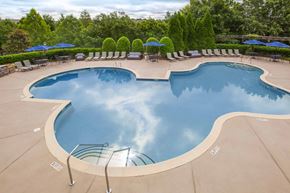 Columbia apartment for rent - a swimming pool with chairs and umbrellas at a resort at Carrington Place at Wildewood, Columbia, 29223