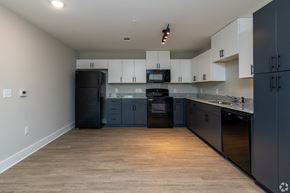 Greenville apartment for rent - A kitchen with black appliances and wooden floors at Dunean Creek Apartments, South Carolina, 29611