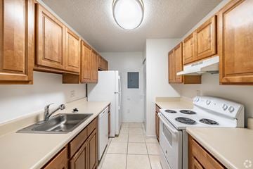 Homestead apartment for rent - A kitchen with white appliances and wooden cabinets.