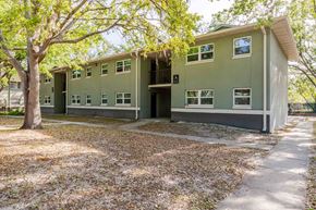 Lakeland apartment for rent - A green building with a tree in front of it.