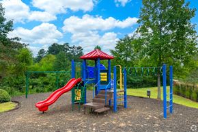 Carrollton apartment for rent - a playground with a red slide and blue playset at Magnolia Lake Apartments, Georgia`