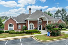 Carrollton apartment for rent - the front of a brick house with a sign in the front yard at Magnolia Lake Apartments, Carrollton, 30117