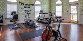 Landover apartment for rent - A gym with exercise equipment and a patterned wallpaper.