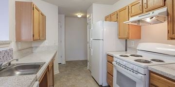 Landover apartment for rent - A kitchen with white appliances and wooden cabinets.