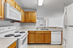 Ladson apartment for rent - a kitchen with white appliances and wooden cabinets at Palms on Ashley River Apartments, South Carolina 29456
