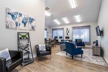Mooresville apartment for rent - A living room with a blue couch and a painting on the wall.