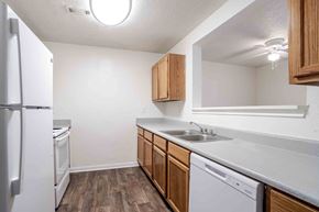 Mooresville apartment for rent - A kitchen with white appliances and wooden cabinets.