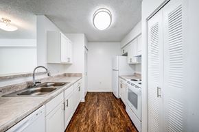 Miami apartment for rent - A kitchen with white cabinets and a wooden floor.